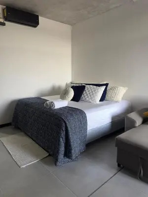 a bedroom with a bed with blue and white pillows at Beko San Benito in San Salvador
