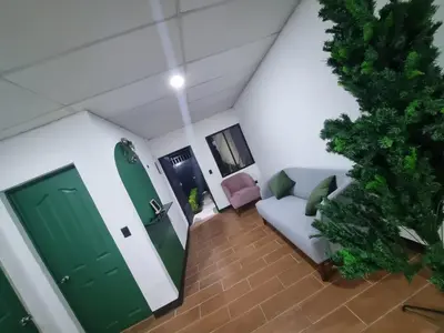 a living room with a couch and a green door at Casa amplia y comoda in San Salvador