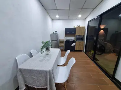 a dining room with a table and white chairs at Casa amplia y comoda in San Salvador