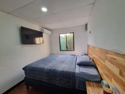 a bedroom with a bed and a flat screen tv at Casa amplia y comoda in San Salvador