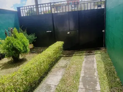 a black door in the side of a green building at Casa amplia y comoda in San Salvador