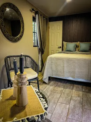 a bedroom with a bed and a table and a mirror at Umbra in Concepción de Ataco