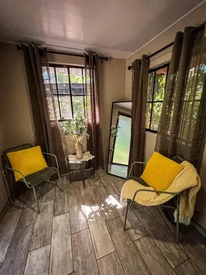 a living room with two chairs and a mirror at Umbra in Concepción de Ataco