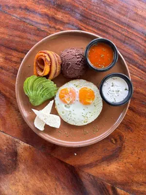 a plate of food with eggs and bread and dips at Umbra in Concepción de Ataco