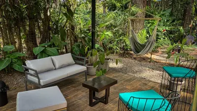 a patio with a couch and a hammock at Umbra in Concepción de Ataco
