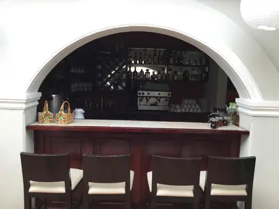a bar with chairs around it with an archway at San Antonio Hotel Boutique in Los Naranjos