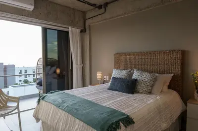 a bedroom with a large bed and a balcony at Spacious 2BR 2BTH El Zonte with oceanview and pool in El Zonte
