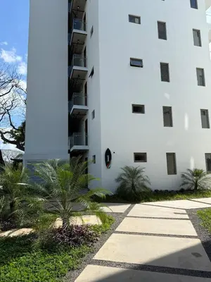 a white building with palm trees in front of it at Spacious 2BR 2BTH El Zonte with oceanview and pool in El Zonte