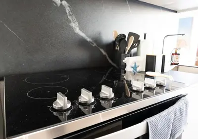 a kitchen with a black counter top with a stove at Spacious 2BR 2BTH El Zonte with oceanview and pool in El Zonte