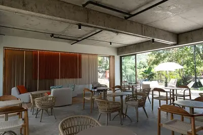a dining room with tables and chairs and windows at Spacious 2BR 2BTH El Zonte with oceanview and pool in El Zonte