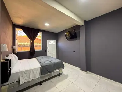 a bedroom with blue walls and a bed and a window at Bella Habitación El Mangal B&B in Suchitoto
