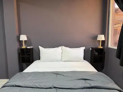 a bedroom with a bed with two lamps on either side at Bella Habitación El Mangal B&B in Suchitoto