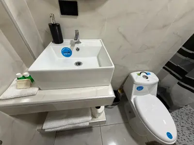a white bathroom with a sink and a toilet at Bella Habitación El Mangal B&B in Suchitoto