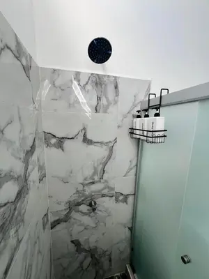 a bathroom with a shower with a marble wall at Home Sweet Home in San Miguel