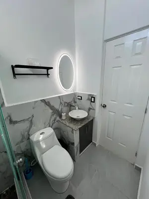 a white bathroom with a toilet and a sink at Home Sweet Home in San Miguel