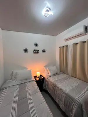 a bedroom with two beds and a light on the wall at Home Sweet Home in San Miguel
