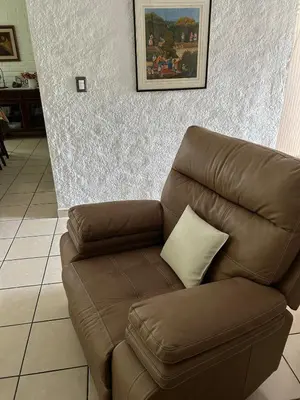 a brown couch with a pillow in a living room at ZonaTorre Futura WTC comfy spacious little house! in San Salvador