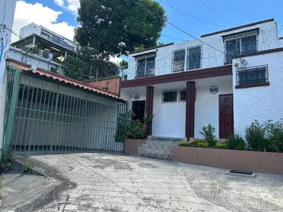 a white house with a gate in front of it at ZonaTorre Futura WTC comfy spacious little house! in San Salvador