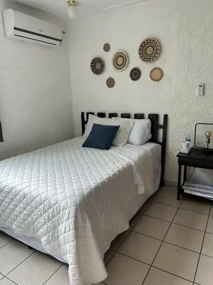 a bedroom with a bed with a white comforter at ZonaTorre Futura WTC comfy spacious little house! in San Salvador
