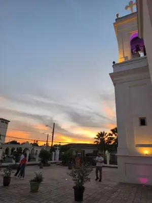 a group of people walking around a building with a clock tower at La Joyona, Cozy House, Atiquizaya