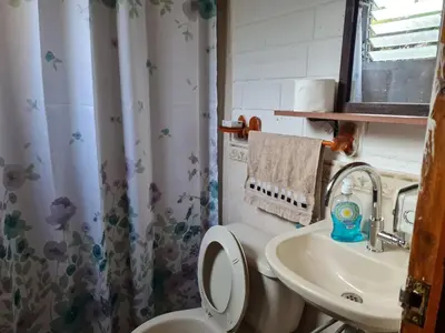 a bathroom with a toilet and a sink at Tata Lodge, Los Romero
