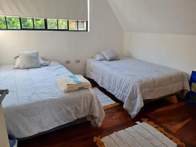 a bedroom with two beds and a window at Tata Lodge, Los Romero