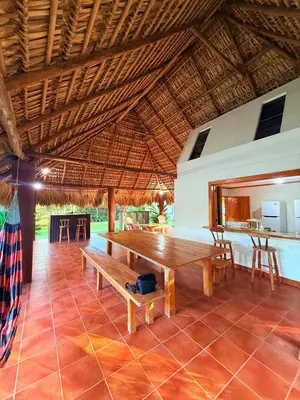 a dining room with a wooden table and a bench at Rancho las Arantzas in Jujutla
