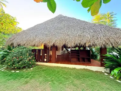 a hut with a straw roof and a lawn at Rancho las Arantzas in Jujutla