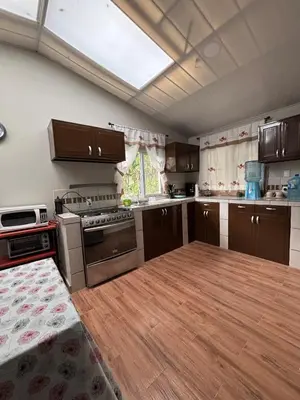 a kitchen with brown cabinets and a wooden floor at Quinta Los 3 Tesoros
