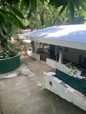a building with a blue roof next to a parking lot at Quinta Los 3 Tesoros
