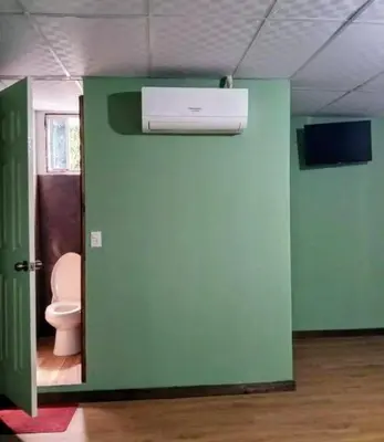 a bathroom with a toilet and a green wall at Noche de luna in San Salvador