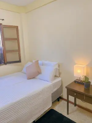 a bedroom with a bed and a table with a lamp at Uong Oasis in San Salvador