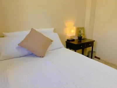 a bed with a pillow and a lamp on a table at Uong Oasis in San Salvador
