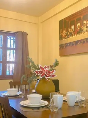 a dining room table with a flower in a vase at Uong Oasis in San Salvador