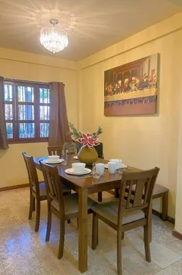 a dining room with a wooden table and chairs at Uong Oasis in San Salvador