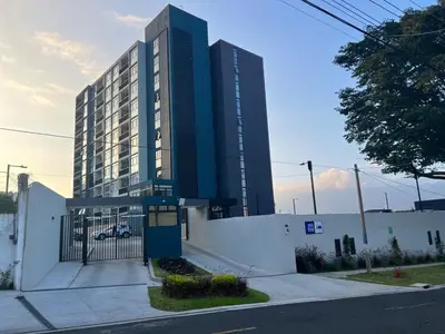 a tall building is next to a white building at Premium comfy apartment Avitat Link, San Salvador in San Salvador