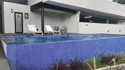 a swimming pool with two chairs and a house at Premium comfy apartment Avitat Link, San Salvador in San Salvador