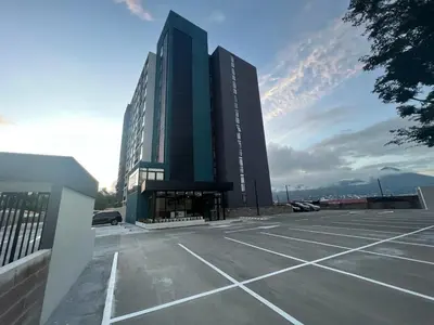 a large building with a parking lot in front of it at Premium comfy apartment Avitat Link, San Salvador in San Salvador