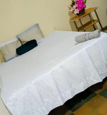 a white bed with a white blanket and flowers on it at La Casona en el Corazon de San Miguel in San Miguel