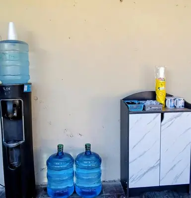 three large bottles of water are sitting next to a table at La Casona en el Corazon de San Miguel in San Miguel