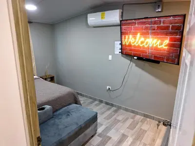 a room with a brick wall with a welcome sign at Apt with 1 Room AC Wi-Fi Kitchen San Salvador in San Salvador