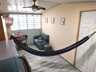 a hammock in a living room with a couch at Apt with 1 Room AC Wi-Fi Kitchen San Salvador in San Salvador