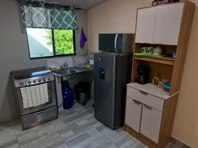 a small kitchen with a refrigerator and a sink at Apt with 1 Room AC Wi-Fi Kitchen San Salvador in San Salvador