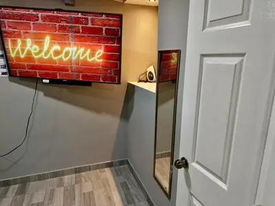 a neon welcome sign on a wall next to a door at Apt with 1 Room AC Wi-Fi Kitchen San Salvador in San Salvador