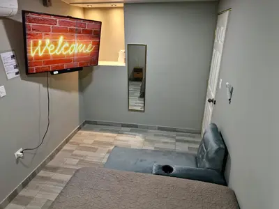a room with a couch and a television on a wall at Apt with 1 Room AC Wi-Fi Kitchen San Salvador in San Salvador
