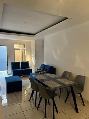 a dining room with a table and blue chairs at Hospedaje en san salvador in San Salvador