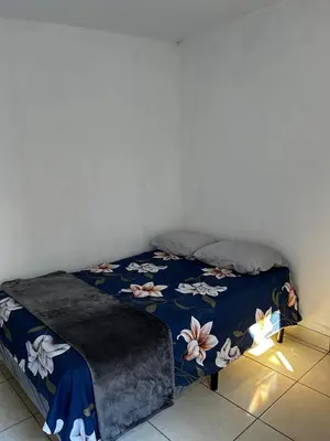 a bedroom with a bed with a blue comforter at Hospedaje en san salvador in San Salvador