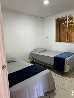 two beds in a room with a window at Hospedaje en san salvador in San Salvador