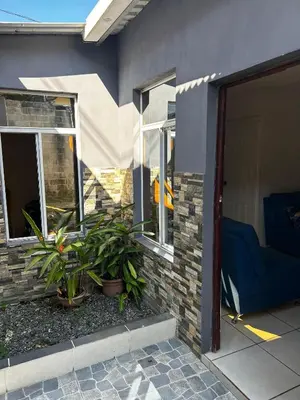 a house with a porch with a blue couch and plants at Hospedaje en san salvador in San Salvador