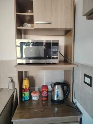 a microwave sitting on a shelf in a kitchen at Family house for 10 guest in Nejapa